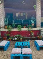 Dos bancos azules en un patio con plantas. en Leafyden Forest Cottages, en Talekhār