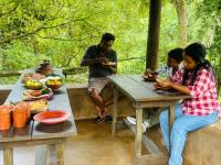 a group of people sitting at a picnic table at Mati Gedara Resort in Digana
