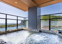 a large swimming pool in a building with windows at LiVEMAX RESORT Atami OCEAN in Atami