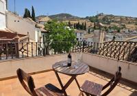 - Balcón con mesa y sillas y botella de vino en El Balcón del Albaicín, en Granada