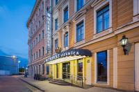 un edificio con un cartel para una tienda en una calle en Eurostars Metropole, en Riga