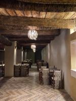 Un comedor con mesas y sillas y una lámpara de araña. en Zella hotel, en Siwa