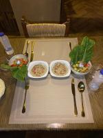 Una mesa con tres platos de comida y tenedores y cucharas. en Zella hotel, en Siwa