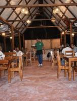 een man die door een kamer loopt met tafels en stoelen bij Eco Cabañas Ah-Kimpech Xpujil Calakmul in Xpujil