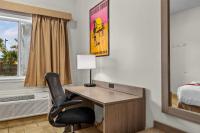 Zimmer mit einem Schreibtisch und einem Stuhl in einem Hotelzimmer in der Unterkunft Ramada by Wyndham &amp; Suites South Padre Island in South Padre Island