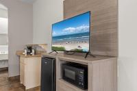 einen Flachbild-TV auf einem Entertainment-Center in der Unterkunft Ramada by Wyndham &amp; Suites South Padre Island in South Padre Island