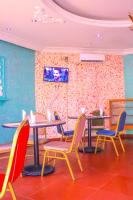 uma sala de jantar com mesas e cadeiras e uma parede em Hôtel de l'Aéroport em Brazavile