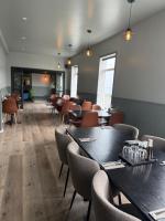 a restaurant with tables and chairs in a room at Hótel Gerpir in Neskaupstaður