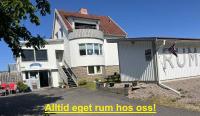 a large white house with a ramp in front of it at Kungshamns Vandrarhem in Kungshamn