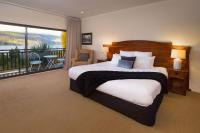 ein Schlafzimmer mit großem Bett und Balkon in der Unterkunft Hidden Lodge Queenstown in Queenstown