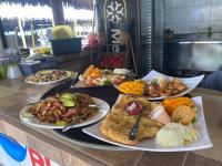 Un montón de platos de comida en un mostrador en Bungalows Garza Blanca a Pie de Playa, en San Blas