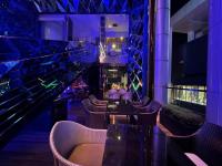 a restaurant with purple lighting and tables and chairs at The Platinum KLCC By Sky Pool in Kuala Lumpur