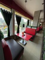 a living room with a red couch and a table at Starline Hotel in Agartala