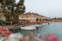 a row of boats in the water next to a building at Pavillon Apartments in Peschiera del Garda