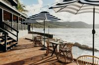 a wooden deck with tables and chairs and umbrellas at The Waves at Cane Bay in Kingshill