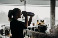 uma mulher em pé atrás de um balcão segurando uma garrafa em Black Rock Oceanfront Resort em Ucluelet