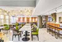 Atour Hotel Harbin Nangang District Government في هاربين: مطعم بطاولات بيضاء وكراسي خضراء
