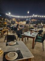 un gruppo di persone seduti ai tavoli su un patio di notte di Peruna Cave a Göreme