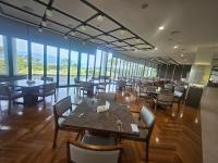 a dining room with tables and chairs and windows at 강진 다산베아채 골프앤리조트 호텔형 in Songhak