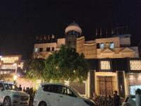 カーンプルにあるHotel Mandakini Royaleの夜間の建物前に駐車した白車