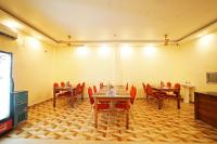 een eetkamer met tafels en stoelen en een tv bij Holiday Beach Resort !! Beach Distance 50 Mts !! in Mandarmoni