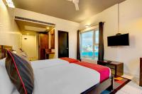 a hotel room with a bed and a television at Hotel O Ulsoor in Bengaluru