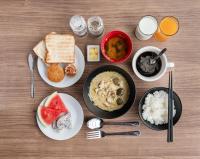 uma mesa com pratos de comida e tigelas de arroz em Kokotel Rayong Beachfront em Ban Pak Khlong Phe
