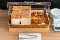 uma cesta de pães e donuts sobre uma mesa em Kokotel Rayong Beachfront em Ban Pak Khlong Phe