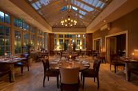 Headlam Hall Hotel & Rural Retreat في Headlam: غرفة طعام مع طاولات وكراسي وثريا