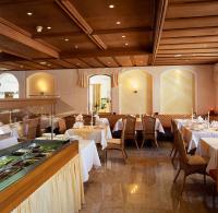 ラムサウ・イム・ツィラータールにあるAlpenhotel Ramsauerhofの白いテーブルと椅子、テーブルサーチャー付きのレストラン