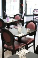 un restaurant avec des tables et des chaises et des verres à vin. dans l'établissement Hôtel - Restaurant Eugenie, à Pontorson