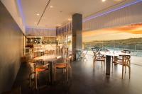 Un restaurante con mesas y sillas y un gran ventanal. en Leiro Residences - Preferred Hotels & Resorts, en Fuengirola