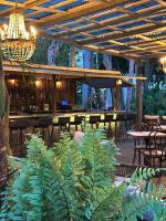 a patio with a bar with tables and plants at Miami River Inn by Renzzi in Miami
