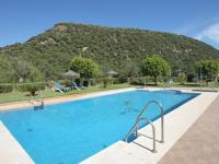 a large swimming pool with a mountain in the background at Hotel El Paso in Vejer de la Frontera