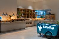 a baby max store with a baby cart in the foreground at Kora Beach Resort Phuket in Bang Tao Beach