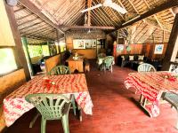 a restaurant with two tables and chairs in a room at HUAHINE - Bungalow Saumon des Dieux in Fare