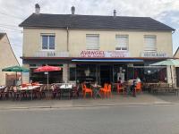 ein Restaurant mit Tischen und Stühlen vor einem Gebäude in der Unterkunft Location appartement entier T1 24h Le Mans in Le Mans