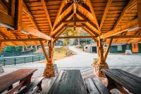 un padiglione in legno con due panchine e un tetto in legno di Hanul Drumul Talienilor a Văleni-Stînişoara