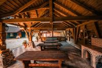 una fila di tavoli di legno in un padiglione di Hanul Drumul Talienilor a Văleni-Stînişoara