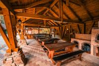 un gruppo di tavoli di legno in un edificio di Hanul Drumul Talienilor a Văleni-Stînişoara