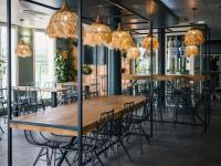 a group of tables and chairs in a room with chandeliers at ibis budget Bordeaux Aéroport in Mérignac