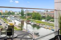 Blick auf einen Fluss von einem Tisch mit einem Getränk in der Unterkunft Waterlane Riverside - SPA, Pool, Gym &amp; Parking by Downtown Apartments in Danzig