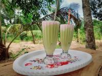 Dos vasos de líquido rosa sobre un plato. en Sigiri Dasa Home stay, en Sigiriya