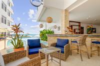 a patio with a bar with a view of the ocean at Royal Kahal Beach Resort in San Pedro