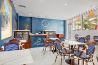 a restaurant with blue walls and tables and chairs at Royal Kahal Beach Resort in San Pedro