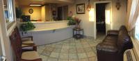 Una sala de estar con un sofá y un bar. en Hilltop Inn &amp; Suites, en Victorville
