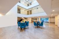 Un comedor con sillas y mesas azules en un edificio. en Limewood Signature - Golf Course Extension Road, en Gurgaon