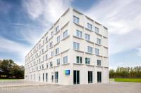 a white building with windows on the side of it at Holiday Inn Express &amp; Suites Ghent by IHG in Ghent