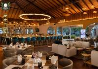 um restaurante com mesas, cadeiras e um bar em Canterbury Hotel & Golf Resort - Only Official Hospitality partner at Canterbury em Gonapola