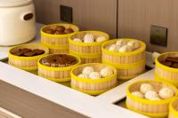 Una fila de contenedores amarillos llenos de diferentes tipos de pasteles. en All-weather Hotel Wutian Old Street Branch, en Wenzhou